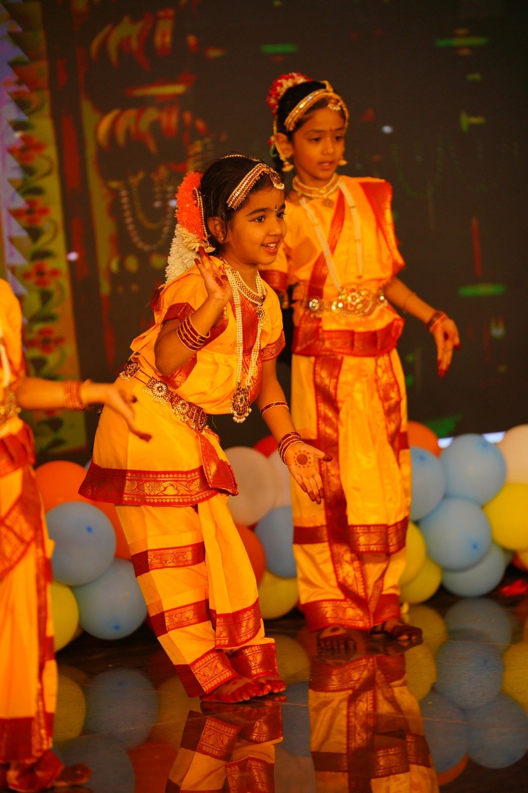 Students performing a classical dance on stage