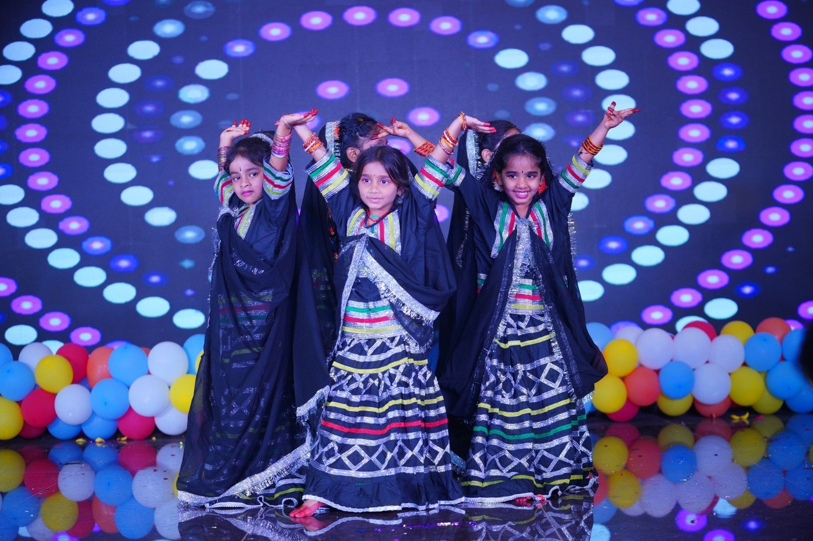 Students performing a colourful group dance